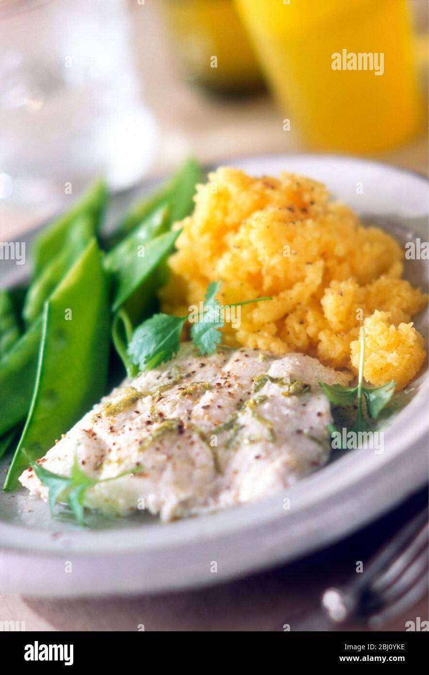 Poached fish with lime shreds and mixed ground pepper with mangetout peas and mashed swede. Garnished with coriander - Stock Photo