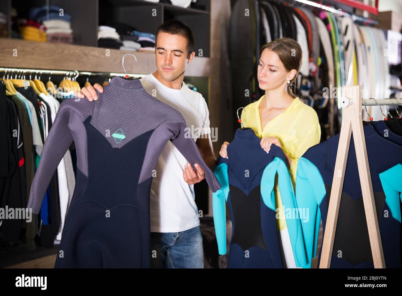 glad couple choosing diving suit in clothing store Stock Photo Alamy