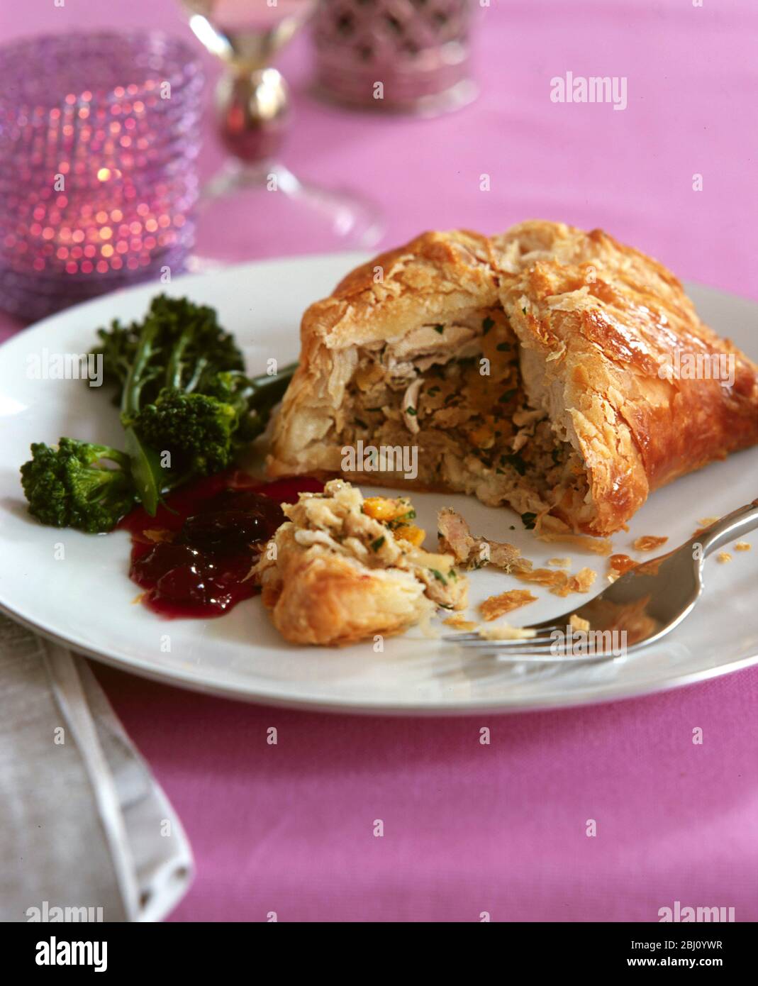 Turkey baked en croute with broccolli and cranberry sauce in festive holiday/Christmas time setting - Stock Photo