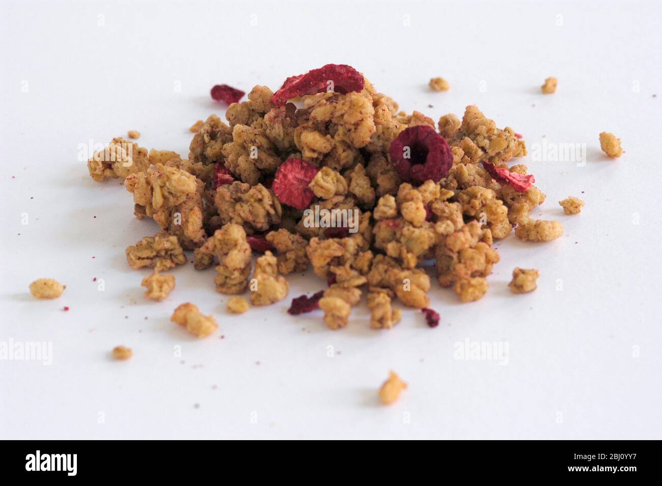 Small pile of breakfast cereal on white background - Stock Photo