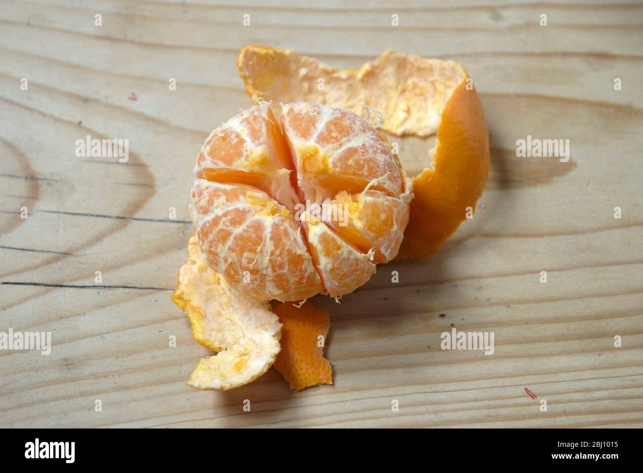 Peeled satsuma on wooden table Stock Photo Alamy