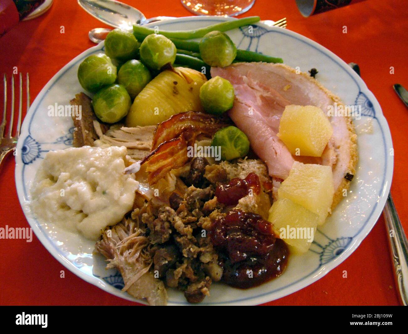 Full Christmas dinner with turkey, ham , bread sauce, stuffing, brussels sprouts, sausagemeat, pineapple relish, roast potato, cranberry sauce on dani Stock Photo