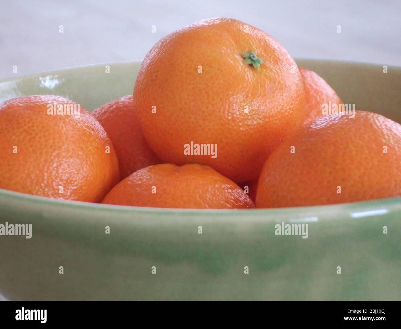 Satsumas in green pottery bowl Stock Photo Alamy
