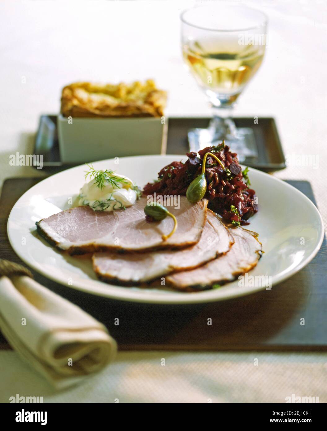 Plate of gammon with red cabbage and caperberries - Stock Photo