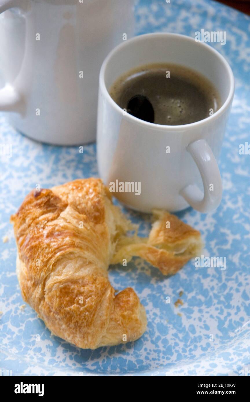 Real coffee made simply in jug with tea strainer and croissant - - Stock Photo