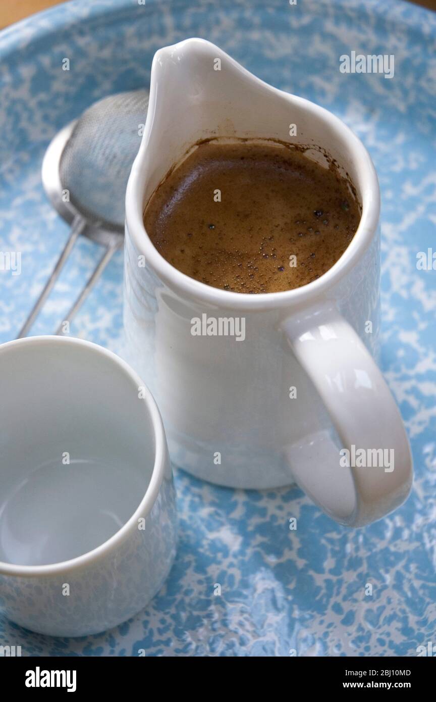Real coffee made simply in jug with tea strainer - Stock Photo