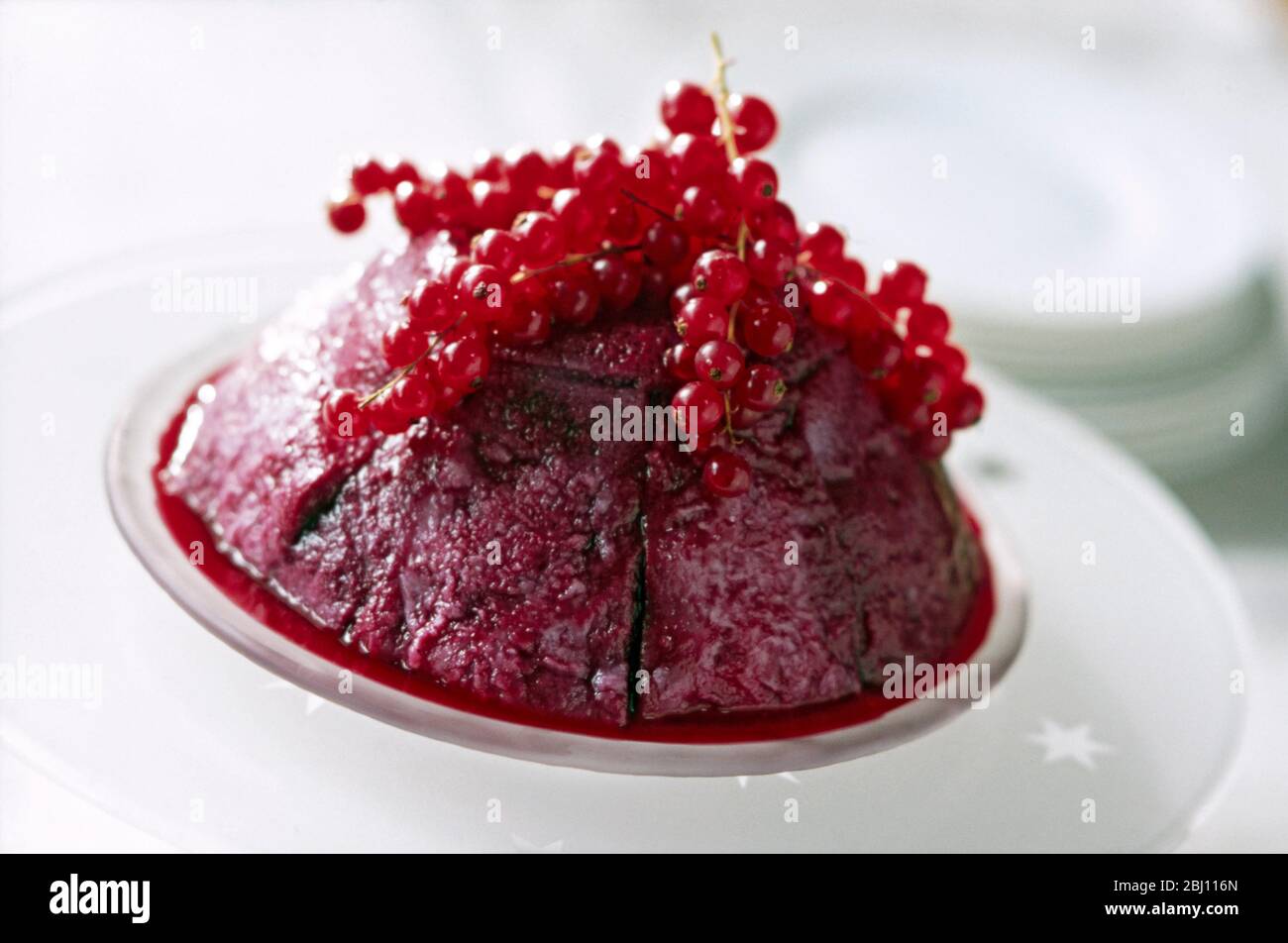 Classic British summer pudding topped with massed redcurrants - Stock Photo