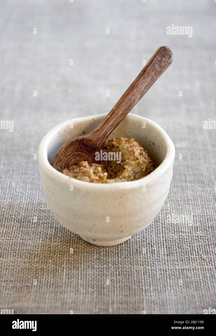 Small handmade bowl with whole grain French Dijon mustard - Stock Photo