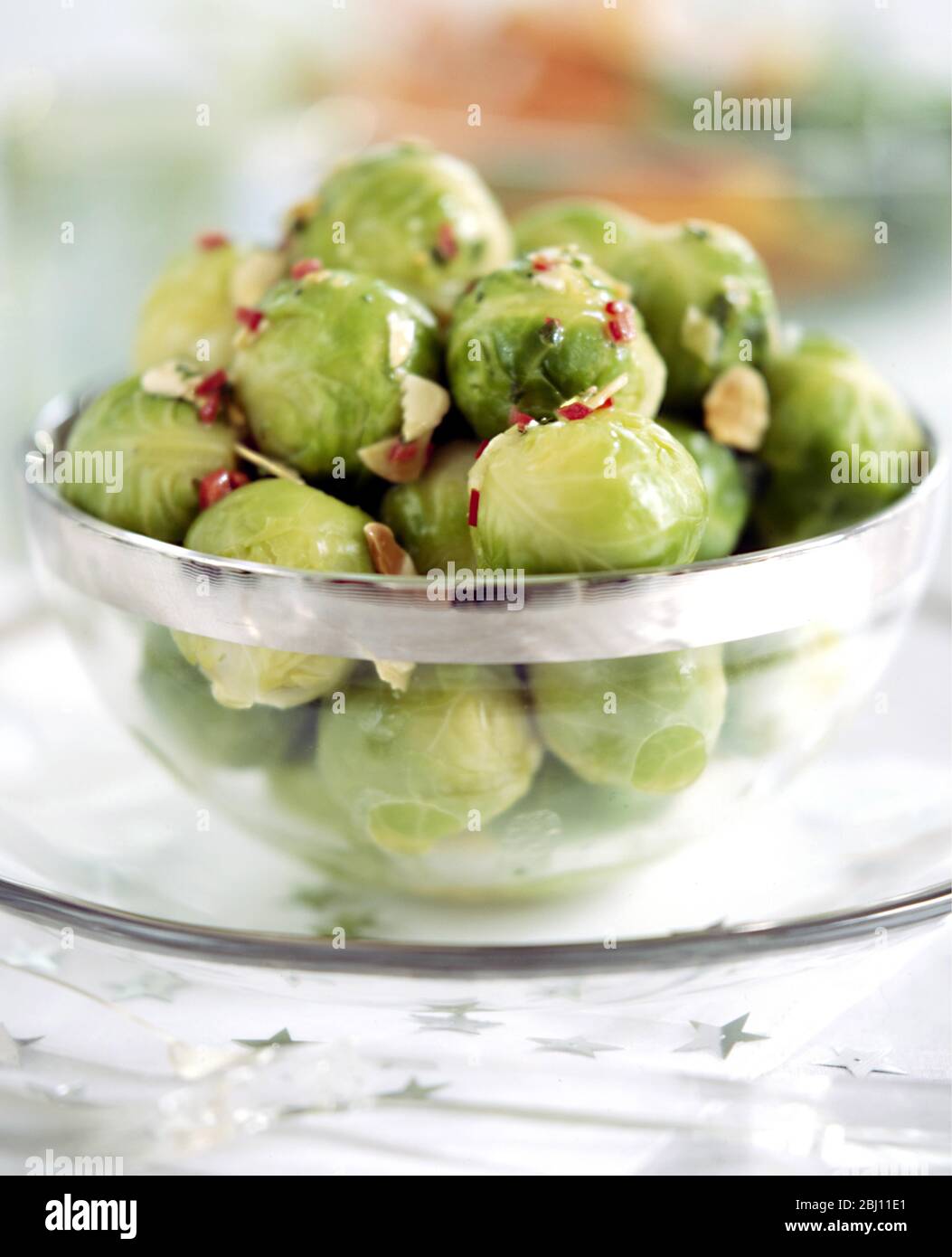 Brussels sprouts with flaked almonds and chili pepper garnish - Stock Photo