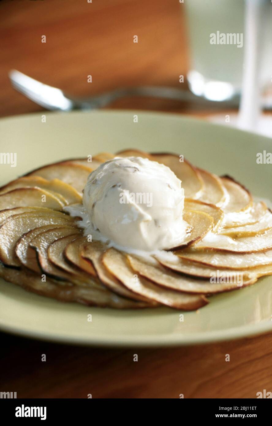 Classic French apple tart with ball of melting icecream in the centre - Stock Photo