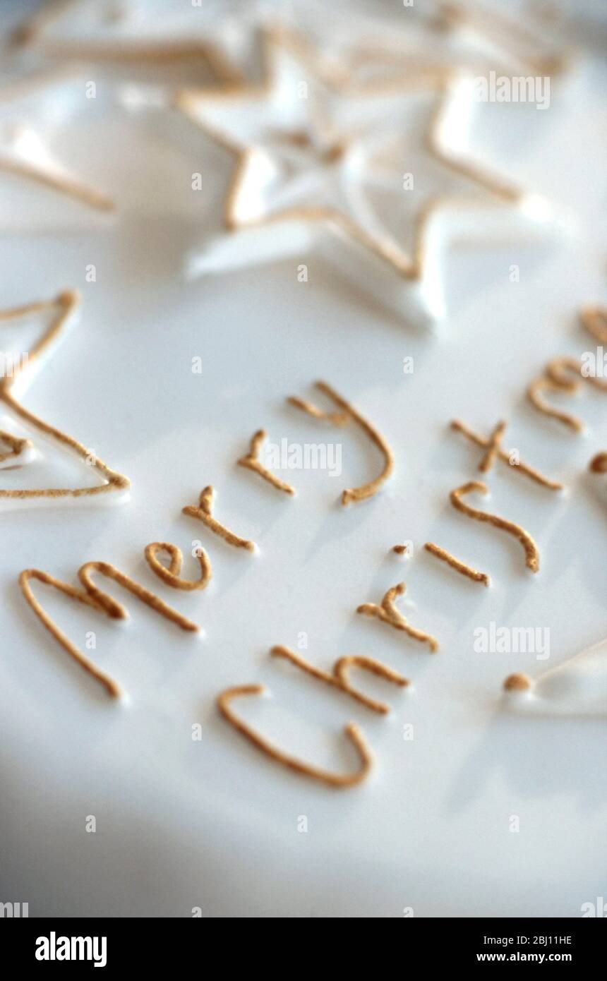 Detail of Merry Christmas icing on iced xmas cake - Stock Photo