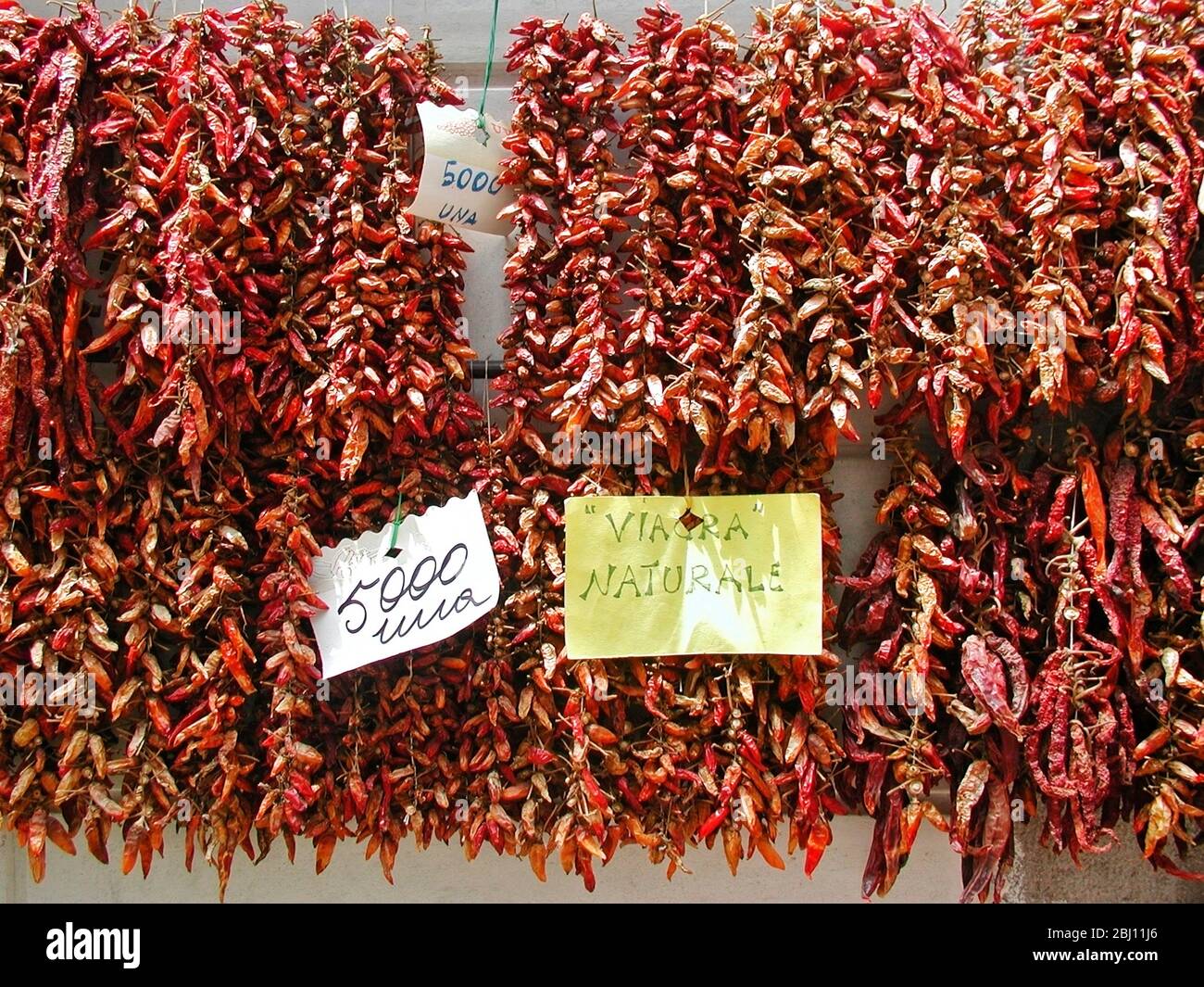 Dried peppers hanging ouside shop in Amalfi Italy - advertising as 'natural Viagra - Stock Photo