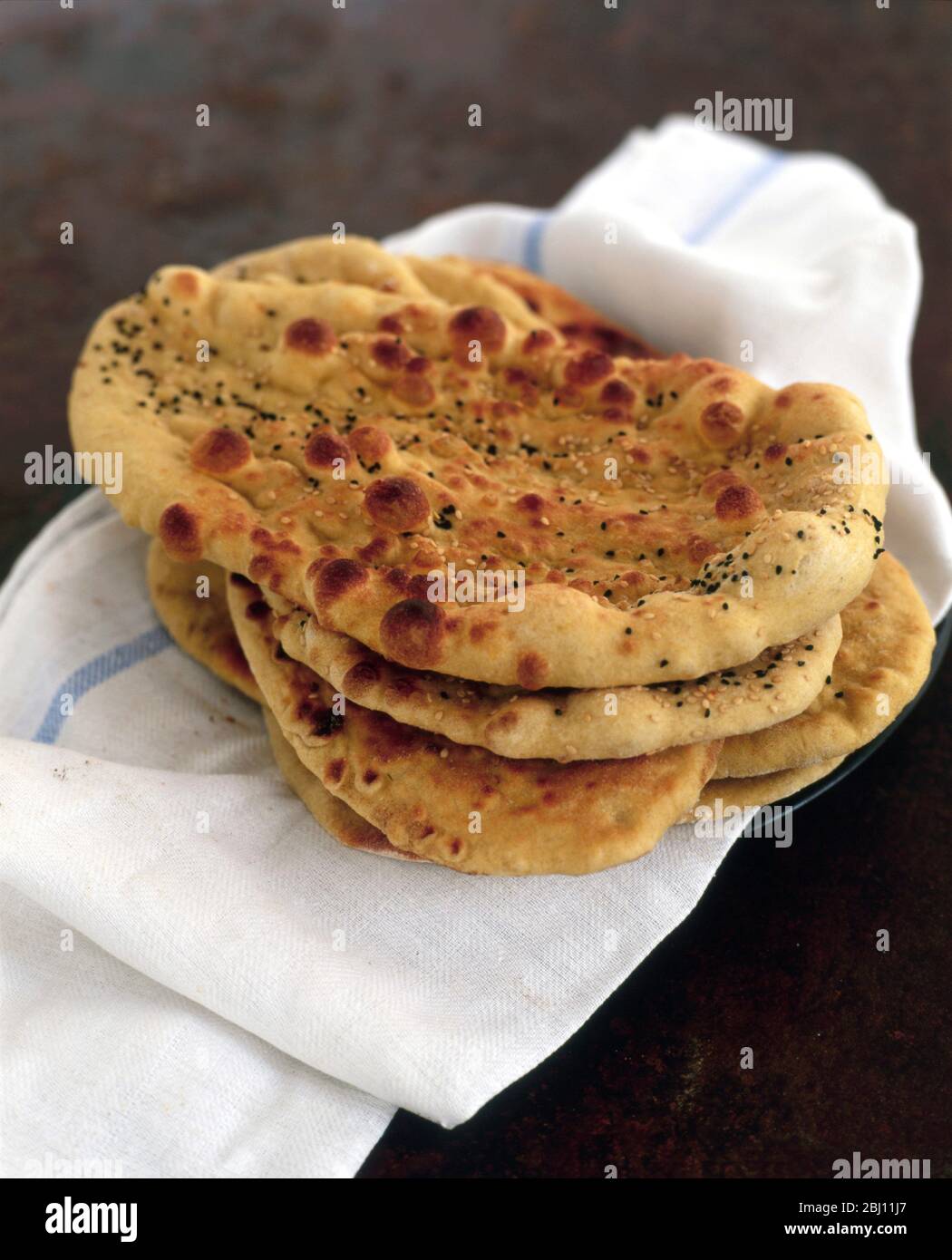 Pile of Indian naan bread on fresh white cloth - Stock Photo