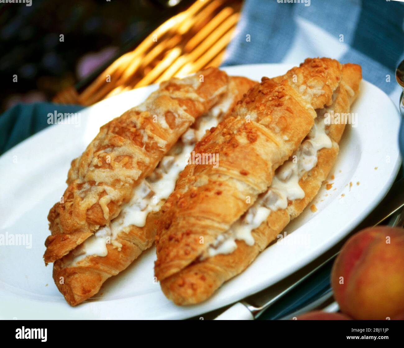 Two croissants with filling of ham and cheese served hot - Stock Photo