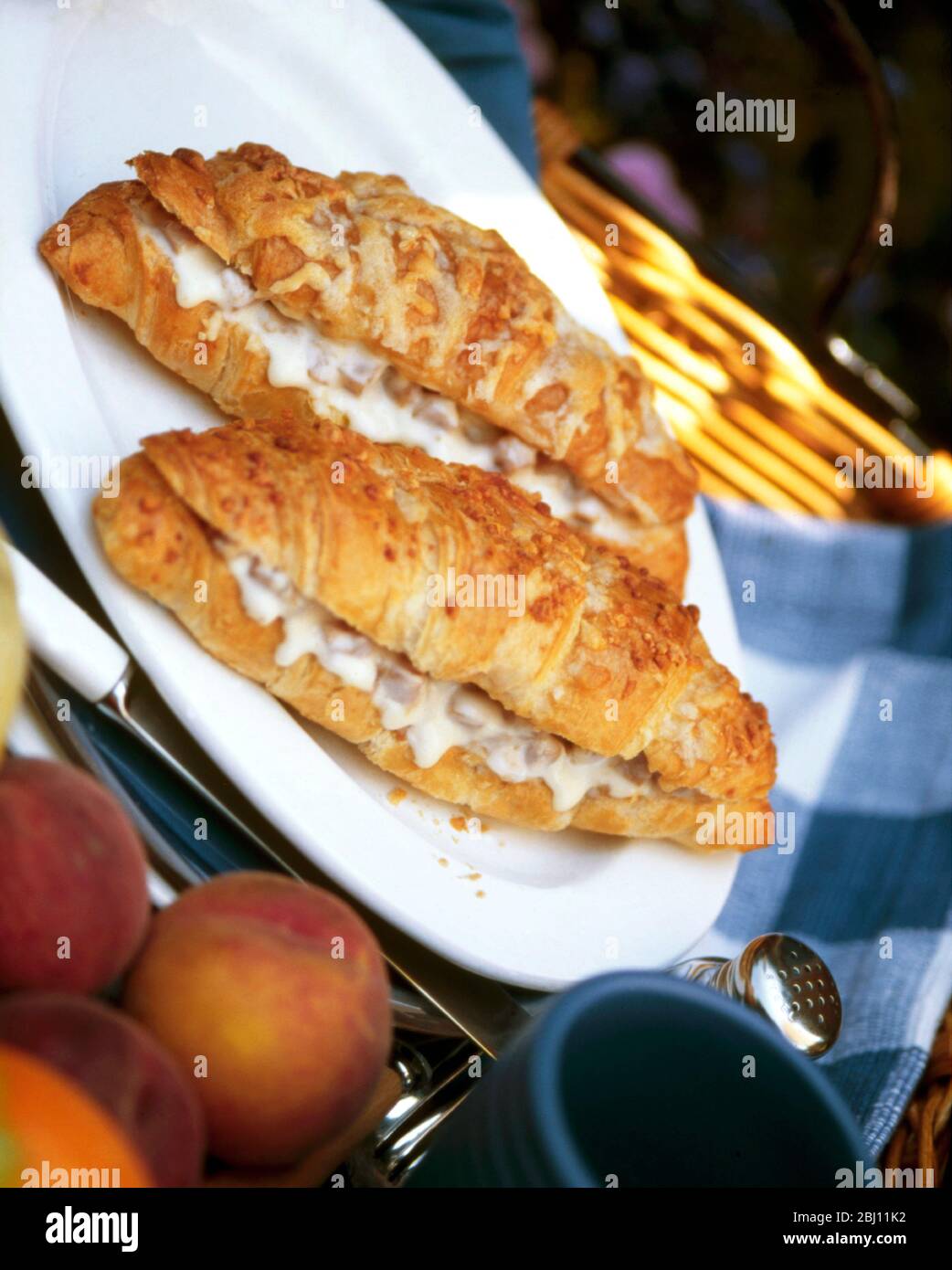 Two croissants with filling of ham and cheese served hot with coffee - Stock Photo