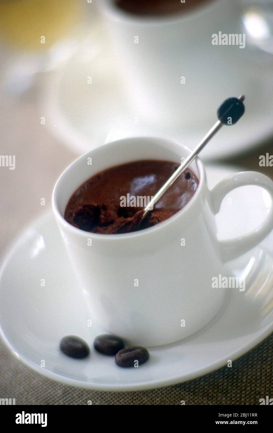 Dark coffee mousse made in small white coffee cups - Stock Photo