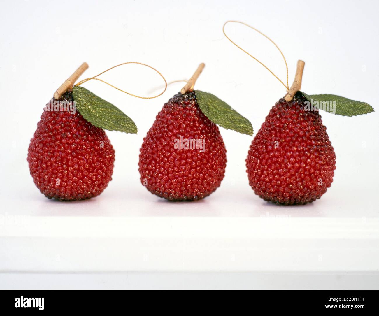 Three red beaded pear shaped christmas decorations - Stock Photo