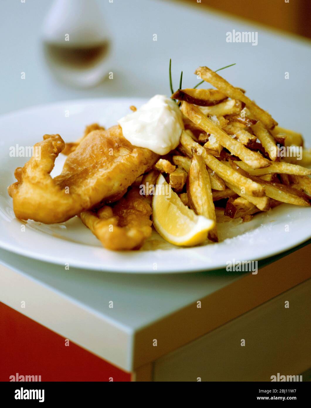 Home cooked fish in batter with 'fat'chips. English national dish which actually grew out of French beignets! - Stock Photo