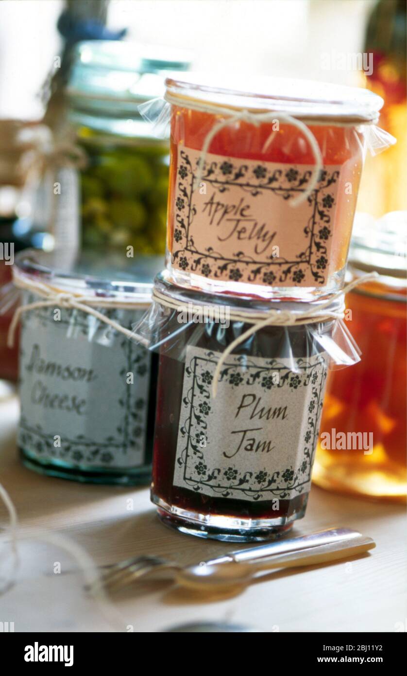 Collection of decoratively packaged jars of fruit jellies and jams - Stock Photo