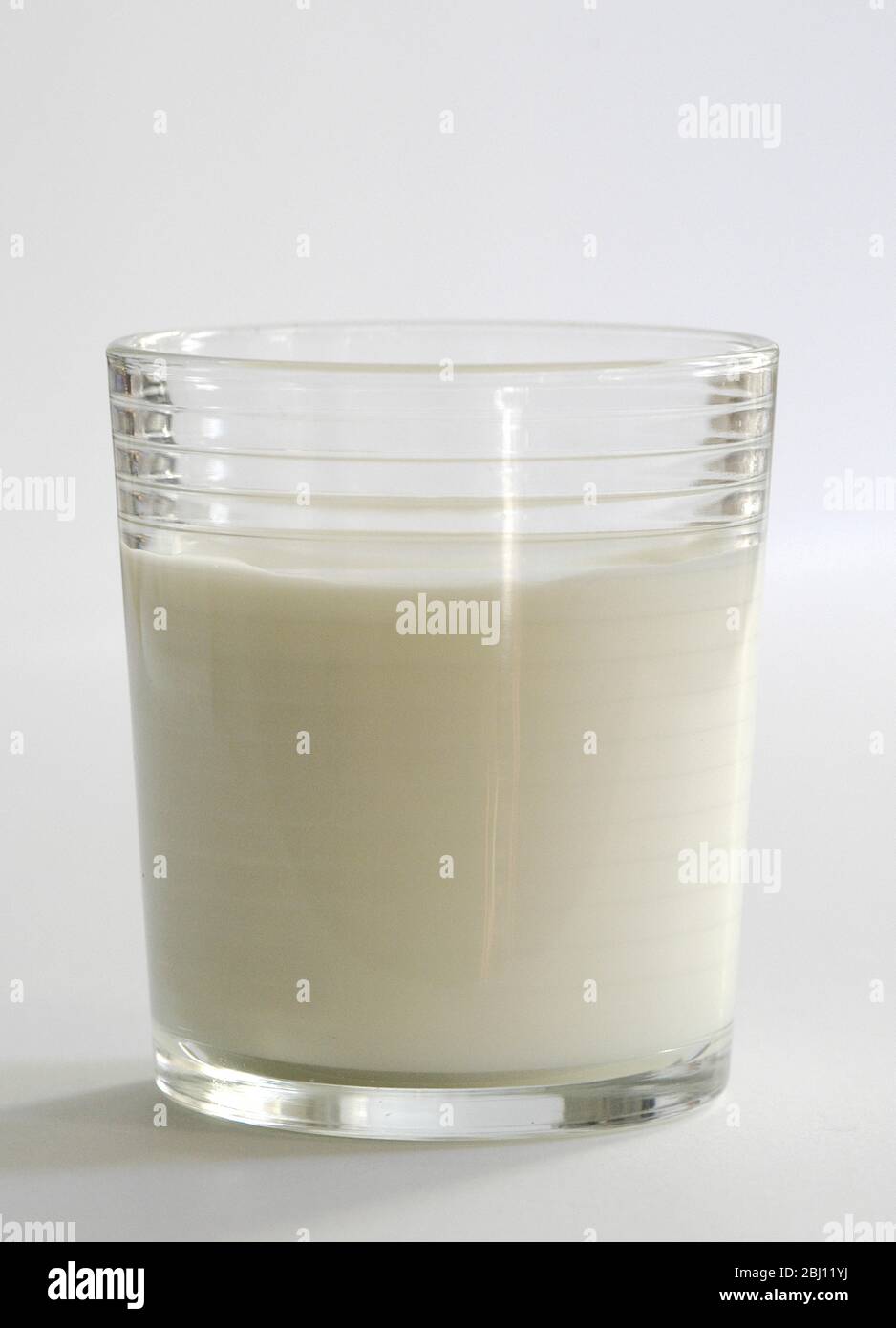 Simple glass of milk on white background - Stock Photo