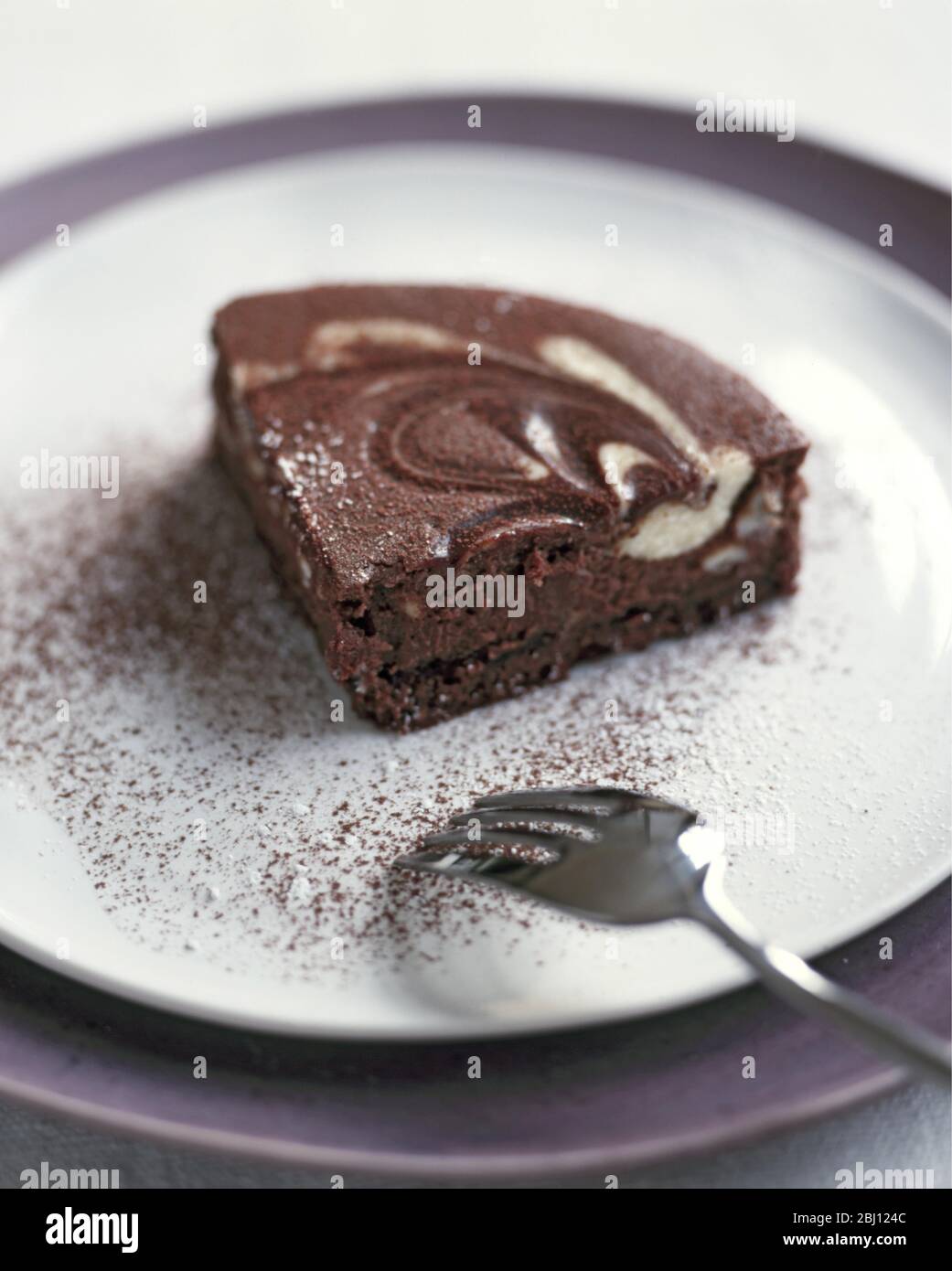Portion of chocolate tart on plate with spoon - Stock Photo