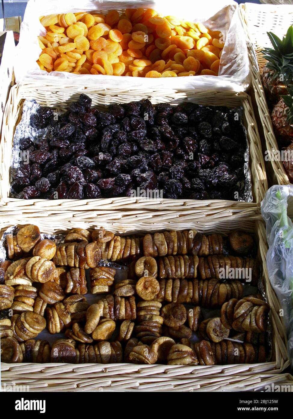 French market stall with dried figs, prunes and apricots in baskets. Northern France, Hesdin - Stock Photo