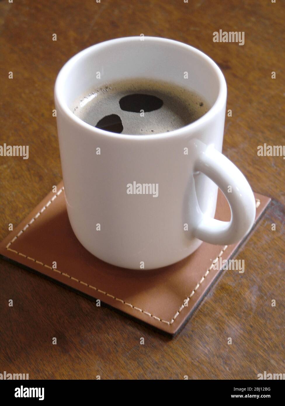 Freshly made black coffee in simple white china mug - Stock Photo