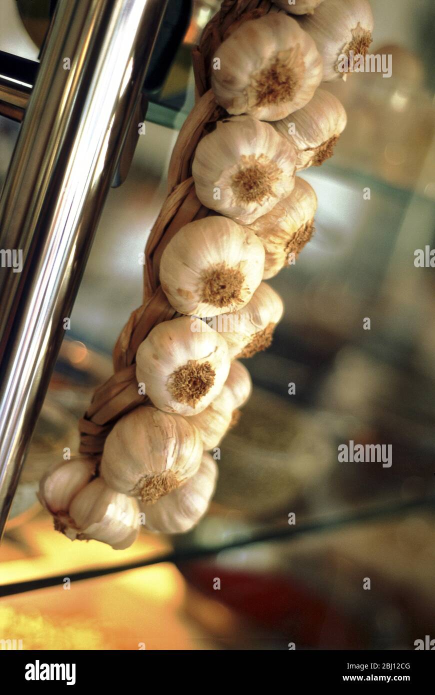 String of garlic hanging in modern kitchen - Stock Photo