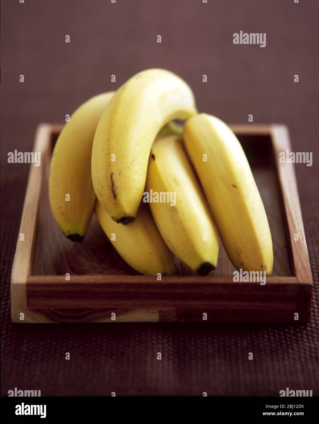 Bunch of bananas on wooden tray - Stock Photo