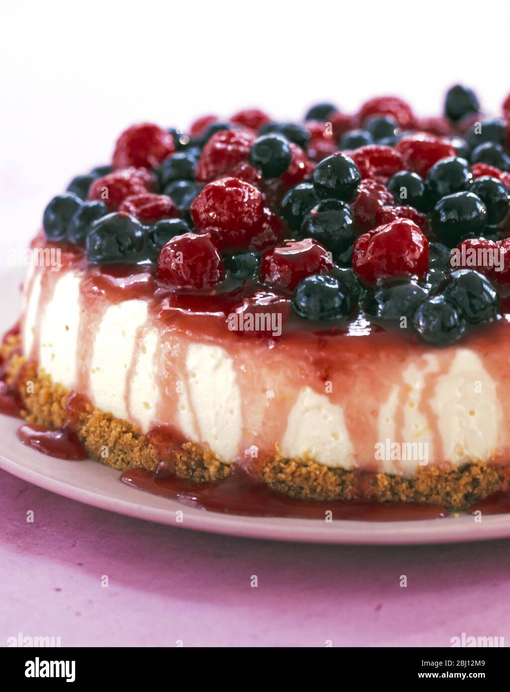 Cheesecake with topping of raspberries and blueberries - Stock Photo