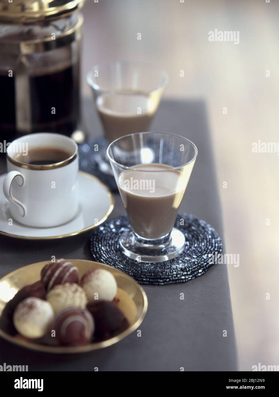 Two glasses of Baileys with coffee and chocolate truffles - Stock Photo