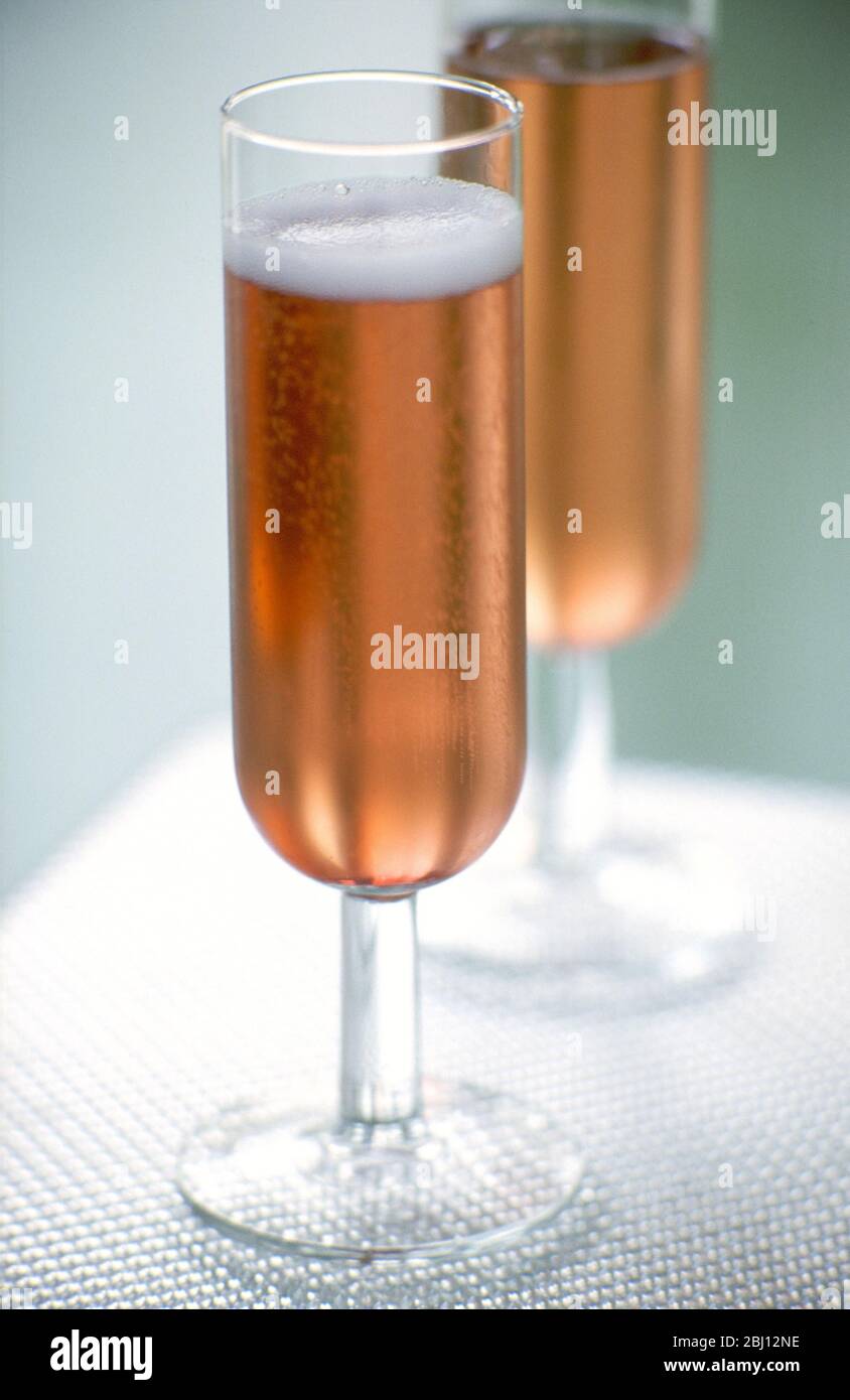 Two flute glasses of pink champagne - Stock Photo