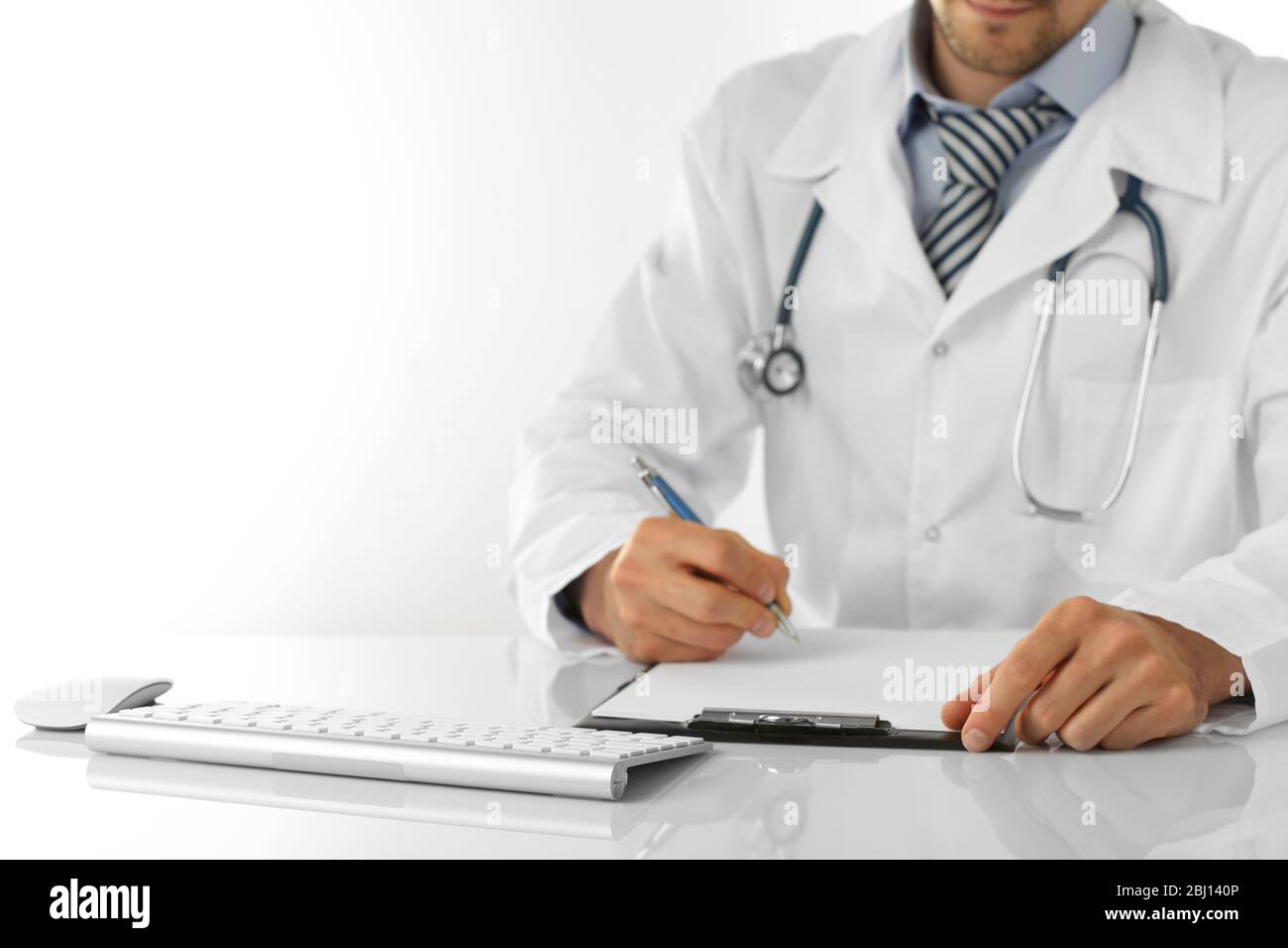 Doctor working at table isolated on white Stock Photo - Alamy