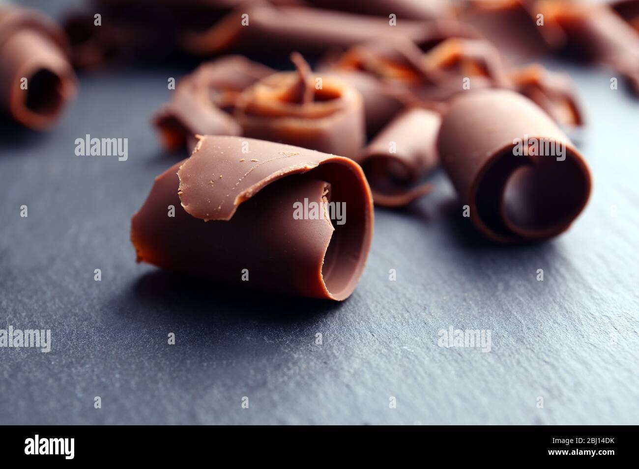 Chocolate curls on wooden table close up Stock Photo - Alamy