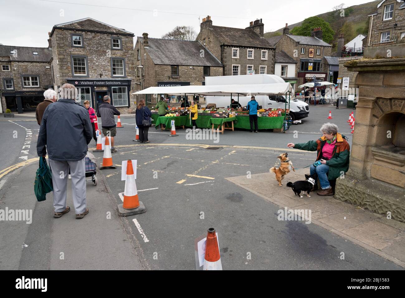 Settle, North Yorkshire, UK. 28th Apr 2020. Covid-19 social distancing queues at the stalls at the weekly street market, in the Yorkshire Dales town of Settle. Credit: John Bentley/Alamy Live News Stock Photo