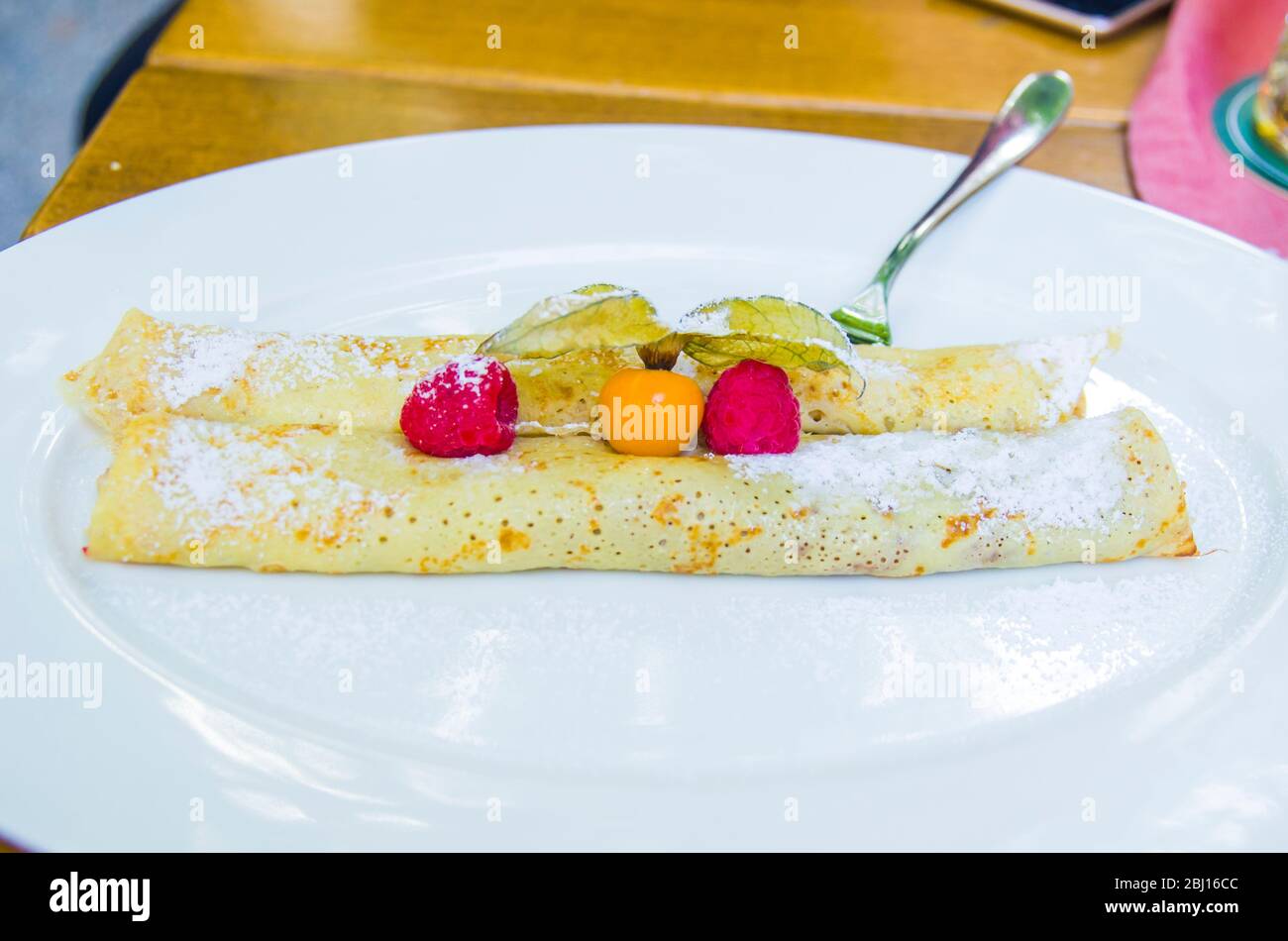 crepes filled with chocolate and berries with wild strawberries and cape gooseberries Stock Photo