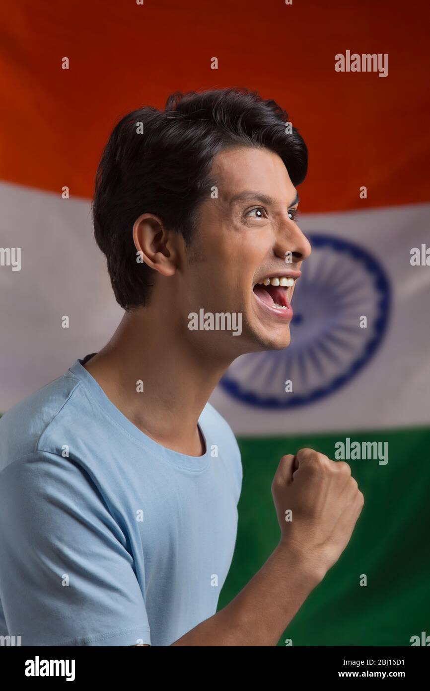 young man cheering in excitement infront of indian flag, independence day Stock Photo