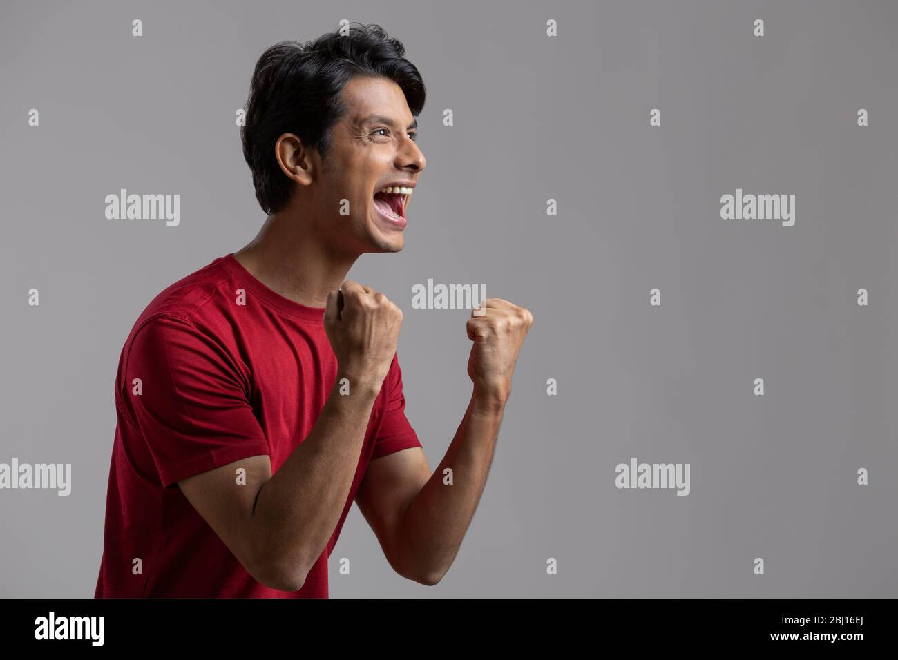 young man clenching fist in excitement and cheering Stock Photo