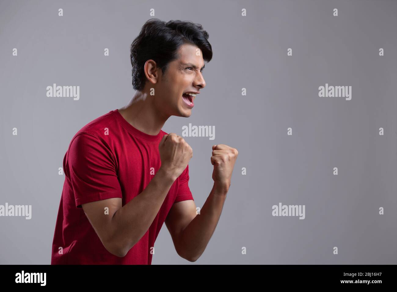 young man clenching fist in excitement and cheering Stock Photo Alamy