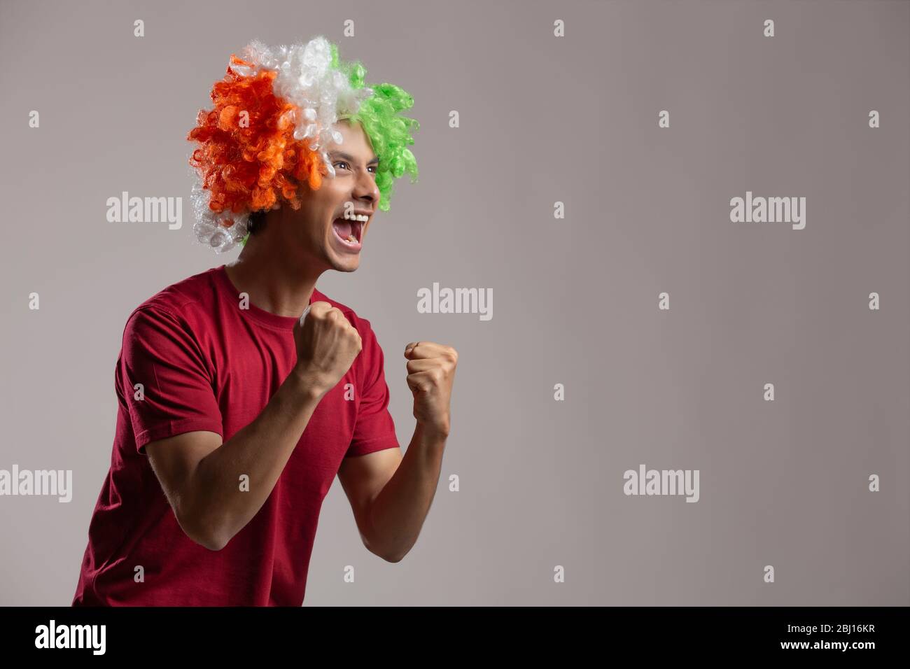 young man wearing tricolour wig and cheering, independence day Stock Photo