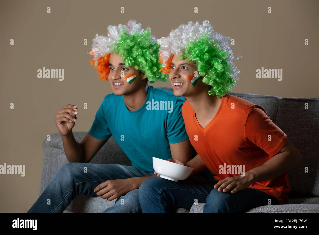 young boys wearing tricolour wig and cheering with a bowl in hand, independence day Stock Photo