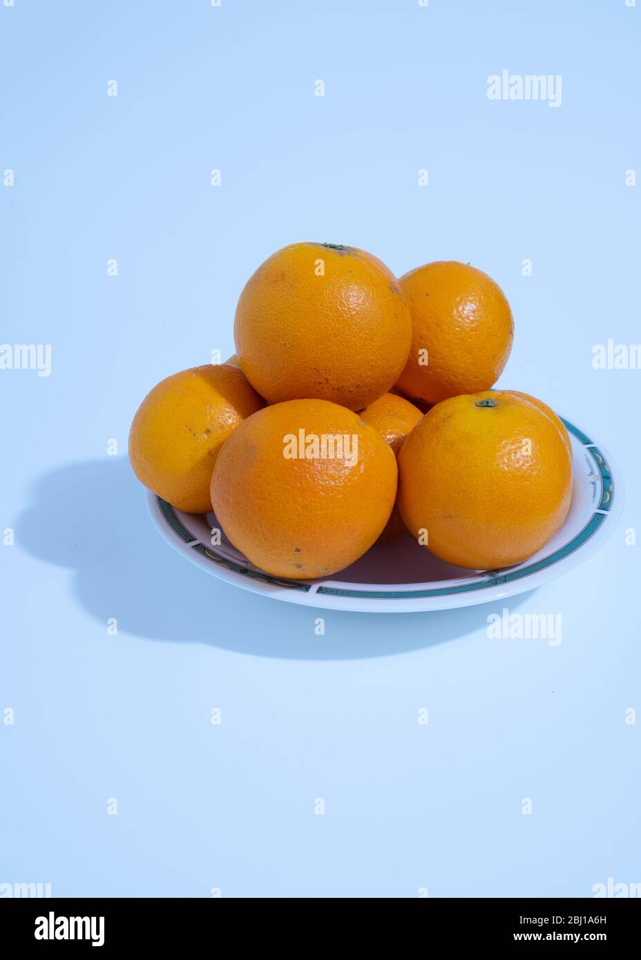 Many vitamin Crich oranges are placed in a ceramic dish on a white