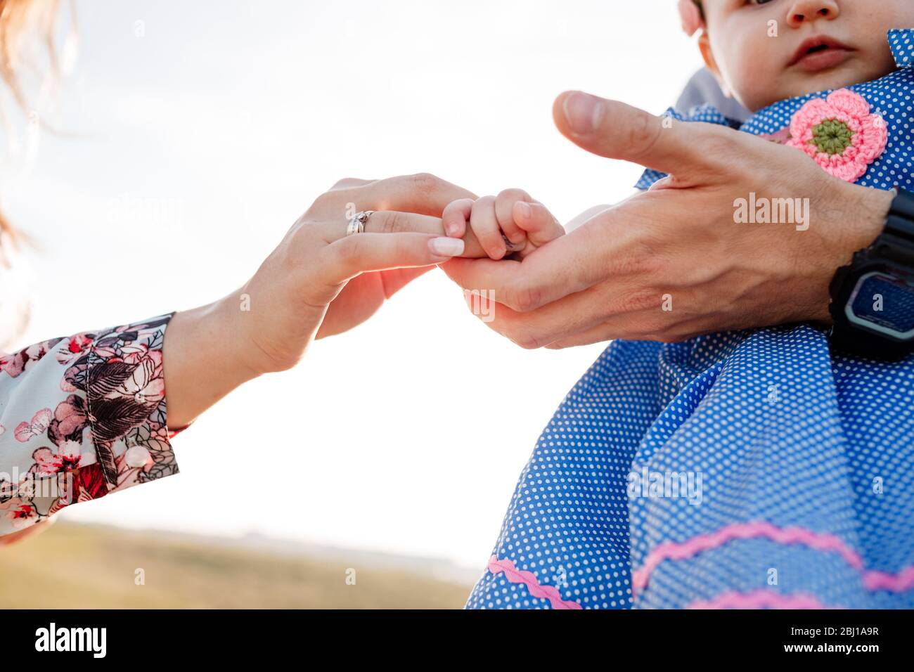 Child's hands on mother and father hands. The concept of summer holiday. Mother's, father's, baby's day. Family spending time together on nature. Fami Stock Photo