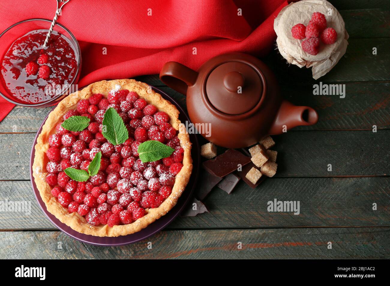 Tart with fresh raspberries and teapot, on wooden background Stock ...