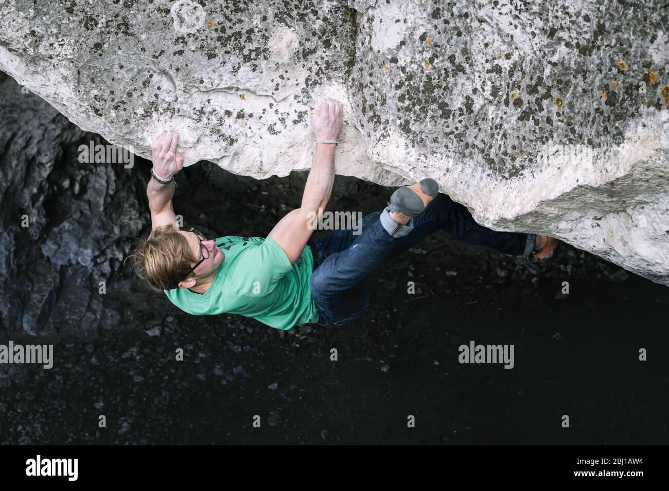 Man is making a boulder in Czarcie Schronisko. Bouldering in rock. Upland Cracow - Czestochowa, Góry Towarne, Polska Stock Photo