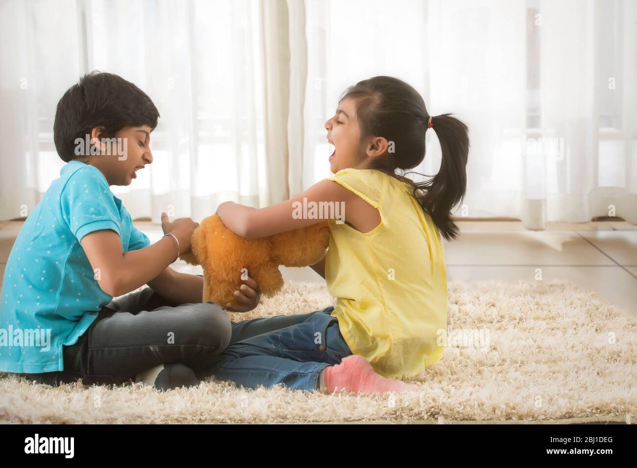 young brother and sister fighting for a toy Stock Photo - Alamy