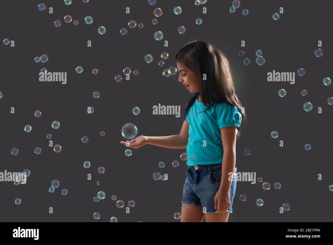 portrait of a young girl holding a bubble in her hand Stock Photo