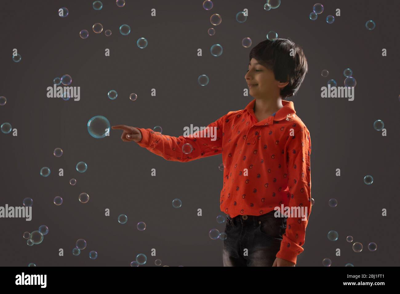 portrait of a young boy popping a bubble Stock Photo