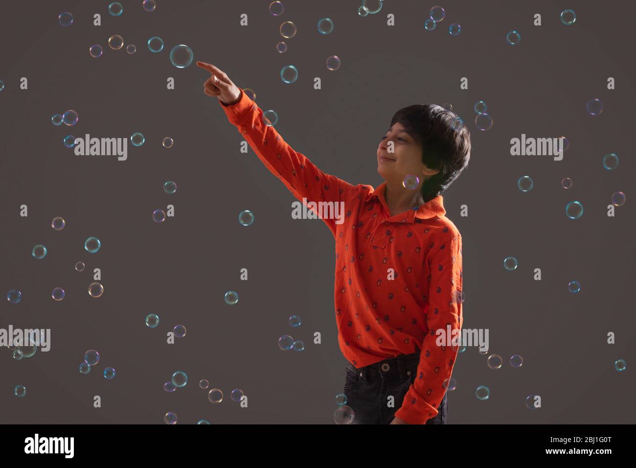 portrait of a young boy popping a bubble Stock Photo