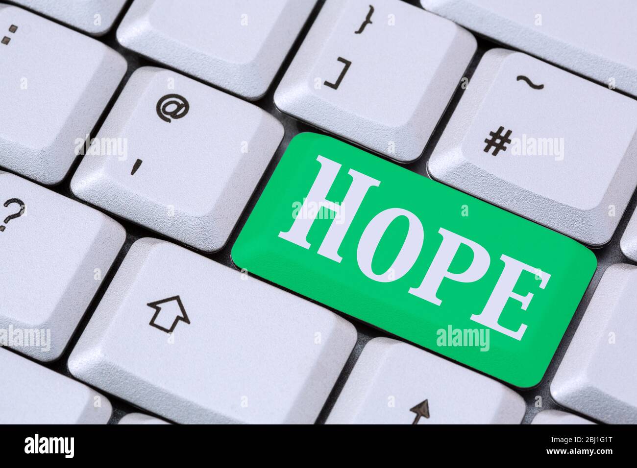 A keyboard with the word HOPE on a green enter key. Hopefulness concept. England, UK, Britain Stock Photo